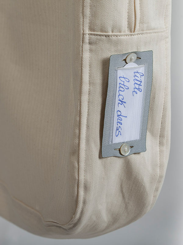 Etichetta della sacca portabito con bottoni in madreperla